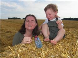 Sieht mal, ich sitze auf einem Heu-Ballen. Das ist lustig. Mama hat gesagt, dass das mal Gras und Getreide war. Das verstehe ich aber nicht. RIMG0062_1.jpg